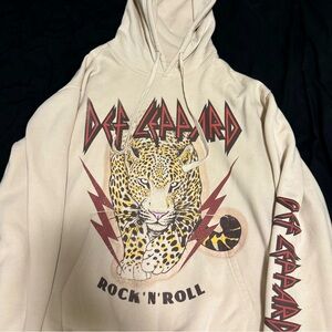Cream Def Leopard hoodie with multi-colored graphics